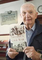 <b>John Schildt</b> holds a copy of his book Frederick in the Civil War at the <b>...</b> - 50c117cea9127.image