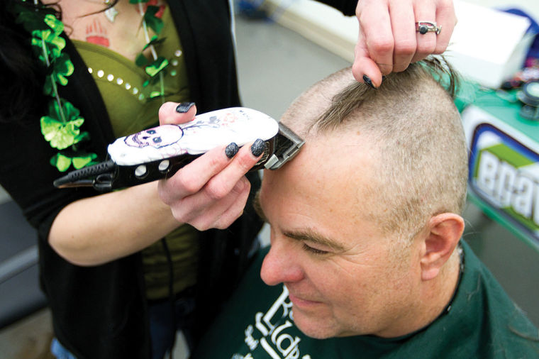 Joel Dingman loses the last of his hair as stylist Cassie Keller runs the clippers over his head one more time. Dingman and others from Dry Fork Station, ... - 52811b2c16fec.image