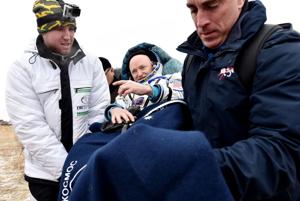 NASA spaceman back from record year flight; gives thumbs up