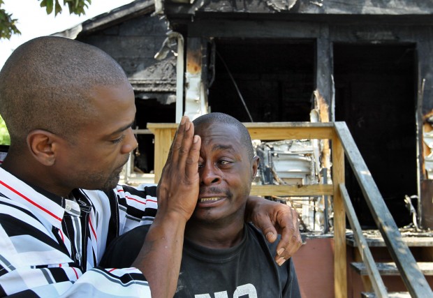 Samuel McClain, 33, left, comforts his friend Ira Ward, 28, Sunday afternoon in front of the burned out home where Ward and other family members lived on 70th Street in E. St. Louis. Ward's cousin, Darius Addison, 11, was killed in the fire. Ward, who lost two cousins in a fire about ten years ago, said he tried to save Addison but the flames drove him back. "He just told me yesterday that he wanted to spend more time with me," said Ward. "I've lost everything," said Ward. J.B. Forbes