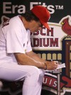 Cardinals manager Tony La Russa makes notes in the dugout