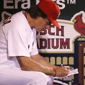 Cardinals manager Tony La Russa makes notes in the dugout