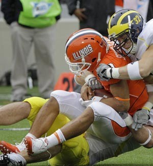 Illinois quarterback Nathan Scheelhaase gets sacked by Michigan