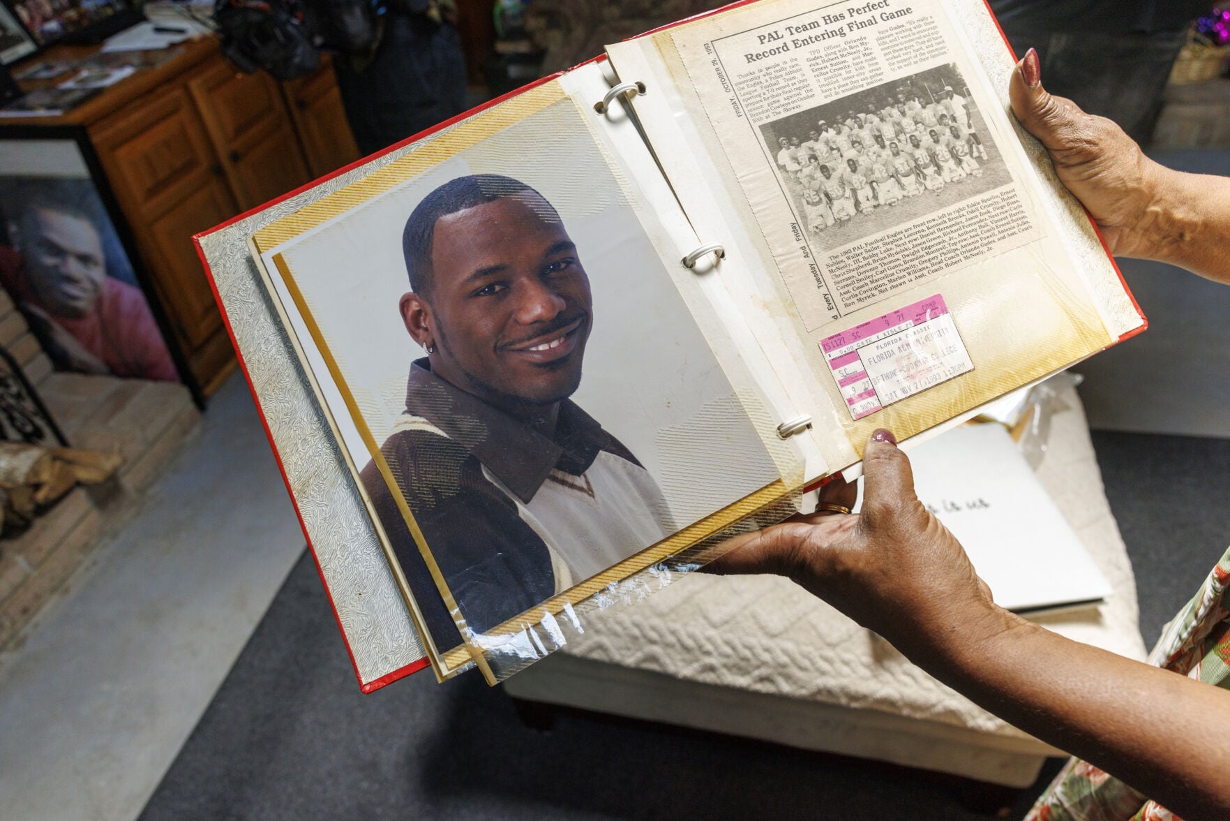 Sherilyn Price holding photo albums of her son Boogie Montrell in her Slidell home