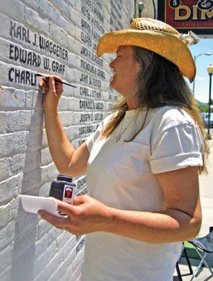 Michele Wayland works to restore names to the wall