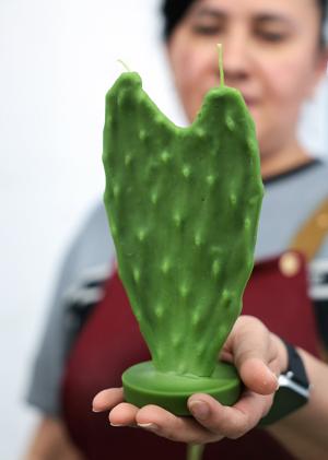LOS ANGELES, CA - June 18, 2026: A worker holds a cactus candle at Happy Organics' studio in downtown Los Angeles on Thursday, June 18, 2026. (Christina House / Los Angeles Times)