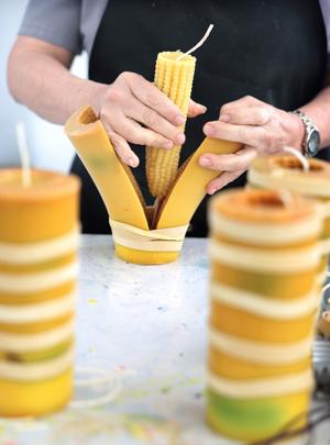 LOS ANGELES, CA - June 18, 2026: A worker pulls a corn candle out of its mold at Happy Organics' studio in downtown Los Angeles on Thursday, June 18, 2026. (Christina House / Los Angeles Times)