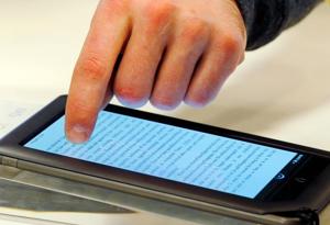 Ben VanderWerp demonstrates the features of a Nook e-reader for a customer at a Barnes and Noble store in Boston, March 18, 2011. Publishers are adapting to rising sales of e-books, and the popularity of smart phones and tablets such as the iPad. The