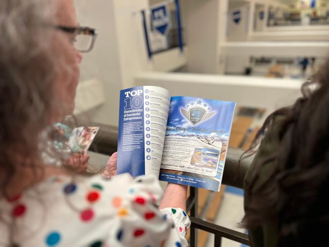 Angila Golik thumbs through a hard copy of the magazine