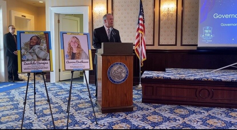 Governor Lombardo with photos of the winners for Nevada Youth of the Year and Nevada Military Youth of the Year.