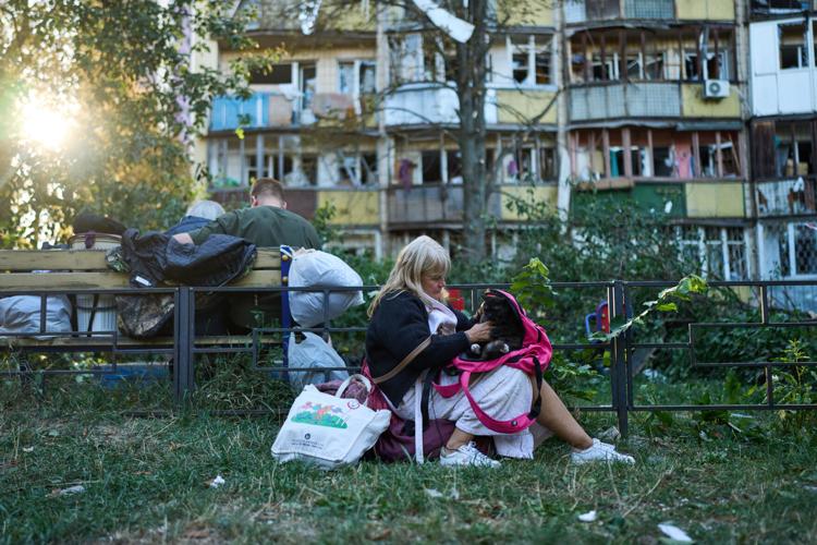 Photos show Kyiv residents clutching pets, collecting bodies after Russian missile and drone attack