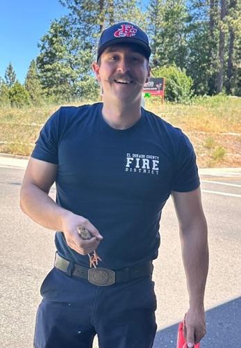 Firefighter holds one baby turkey
