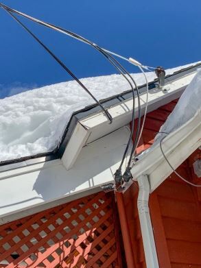 An image of 240V power service drops that may be covered in snow by roof cornices. If contact is made  by an aluminum shovel or ladder when the snow is being cleared, the results could be fatal.