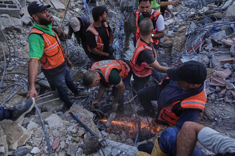 Photos show rescuers recovering bodies after strike-damaged building collapses in Gaza
