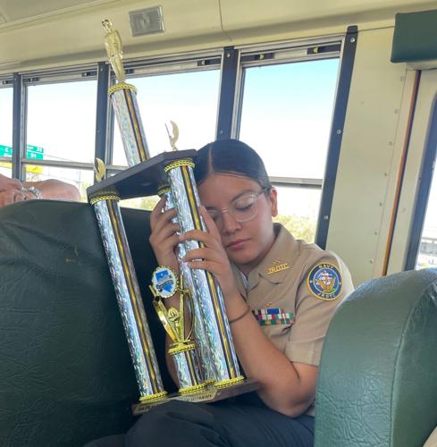 Cadet Alexa Zaragoza-Garcia holding the 1st place trophy for her Armed Regulation Team.jpg