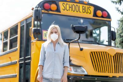 Masked teacher and bus