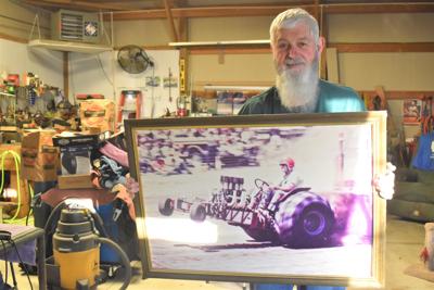 Bill VanDe Creek holds a picture of himself riding mini hot rod