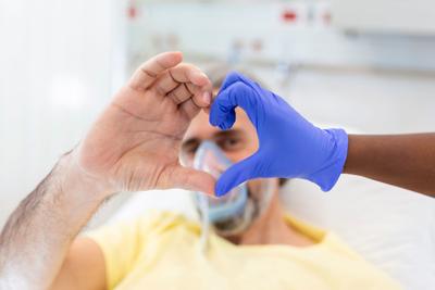 STOCK Doctor and patient make finger heart shape