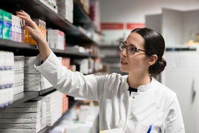 STOCK Dedicated pharmacist taking a medicine from the shelf during work