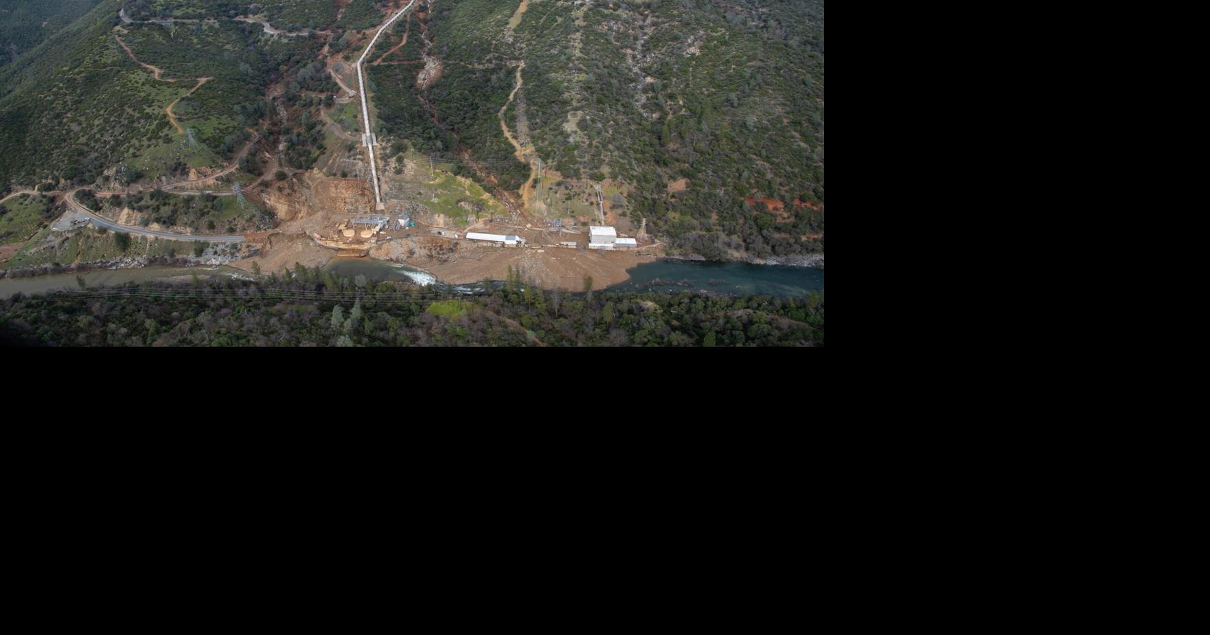 Oil boom draped across lake below power plant disaster