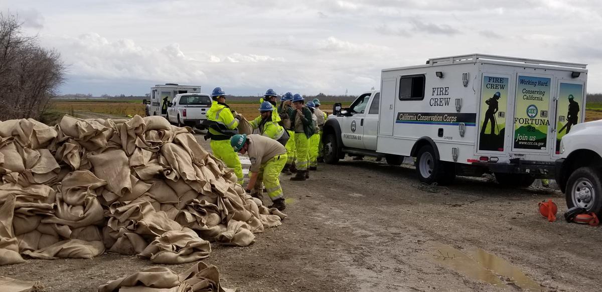 Workers reinforce J Levee to support high water levels