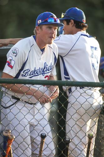 Youth Baseball Player Behind The Dugout Fence During A Game In