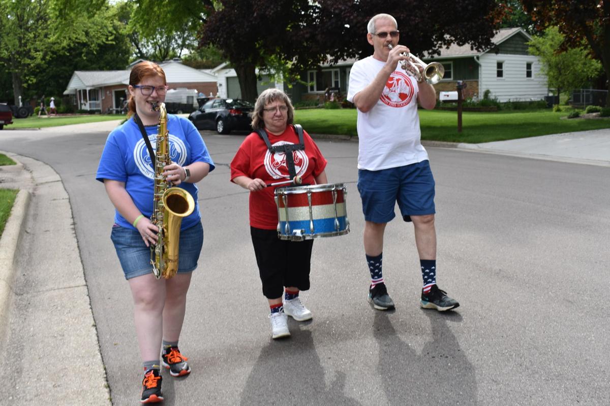 Sarah Hemmerle marches down the street with her parents while they play their instruments.