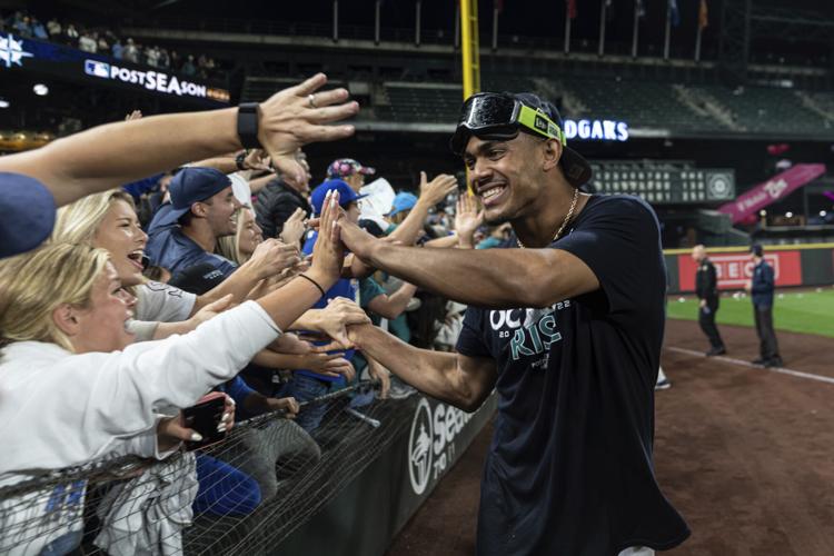 Seattle Mariners' Julio Rodriguez smiles as he talks with a fan