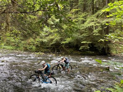 Mountain bike riders fording creek