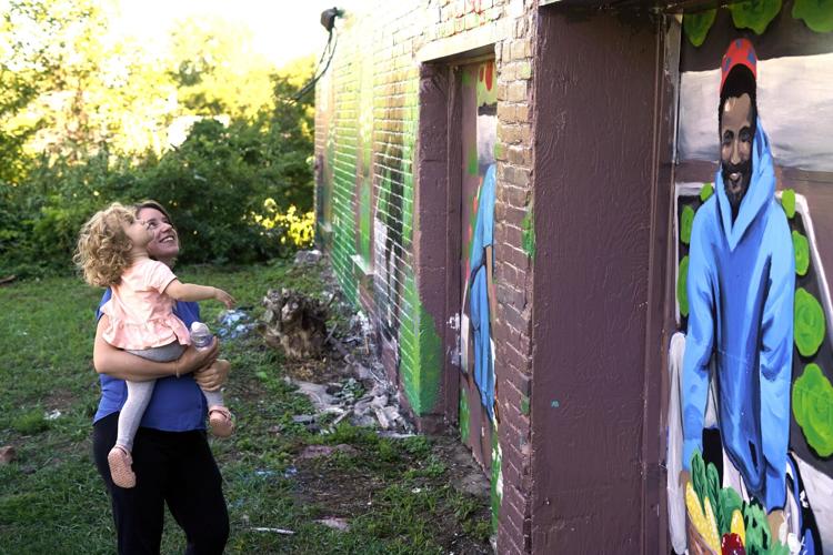 Allison Egan and her daughter Margot, age 2, enjoy the mural “I wish…for a Greener Future”