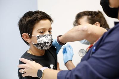 Child wearing mask getting vaccine