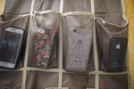 Cell phones hang on a door in a shoe bag (copy)