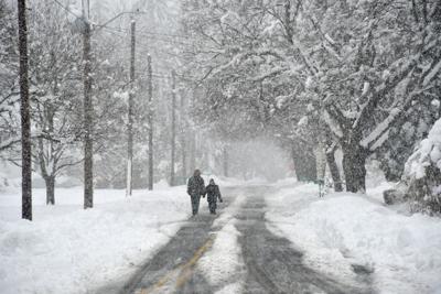 Two people walk down a road