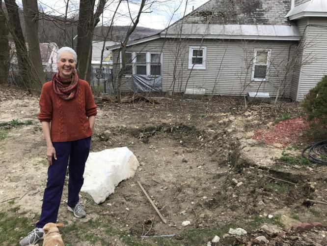 Karen curlee next to a large hole in her backyard