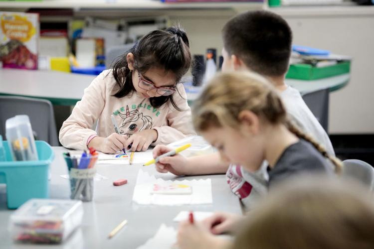 students decorate tiles in classroom