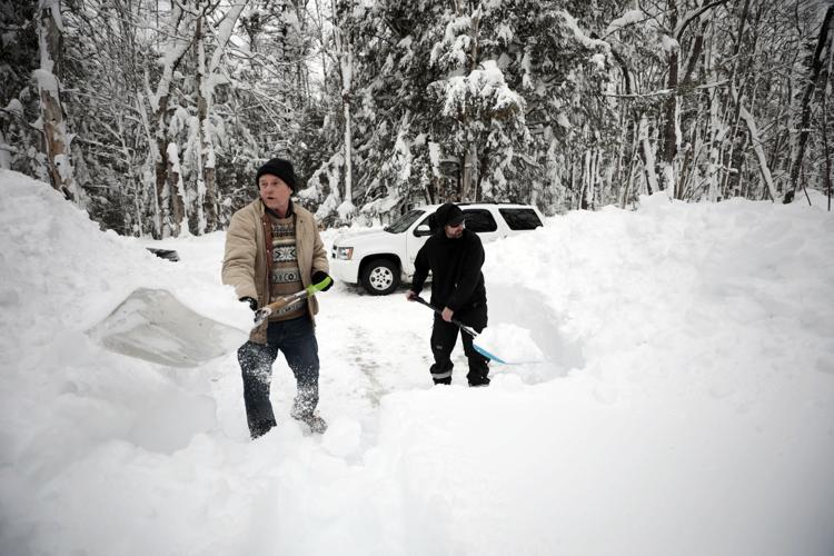 Caleb Mitchell and David Bachand dig through deep snow