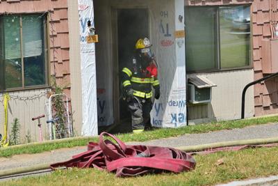 A firefighter walks out of a house