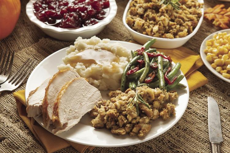 Thanksgiving dish filled with turkey, stuffing, green beans and mashed potatoes