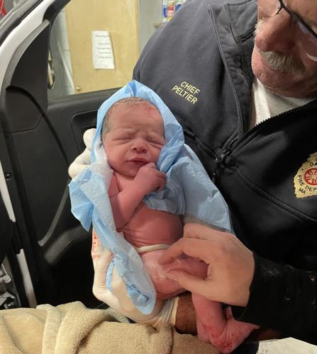 Dalton Fire Chief James Peltier holds newborn