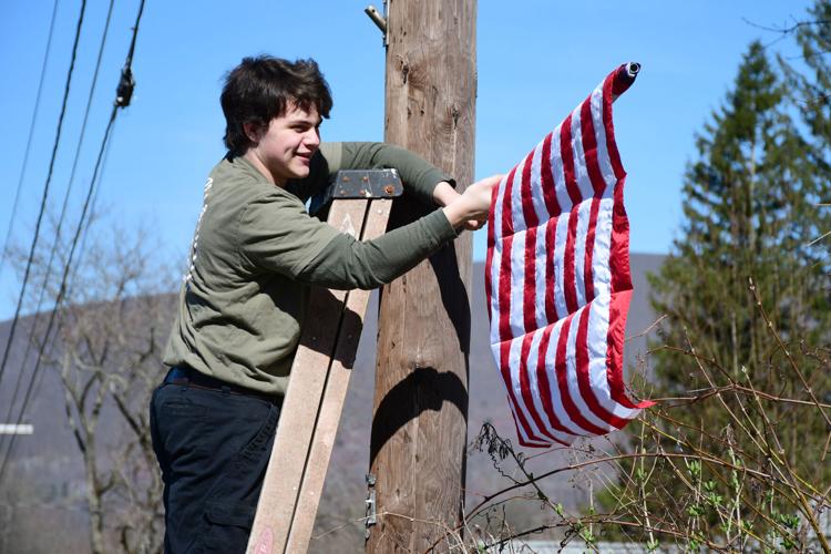 A young man hangs a flag