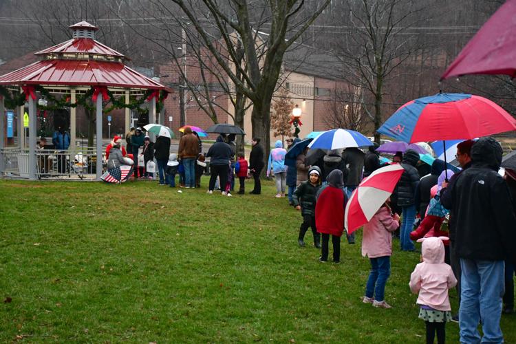People line up in the rain to see Santa