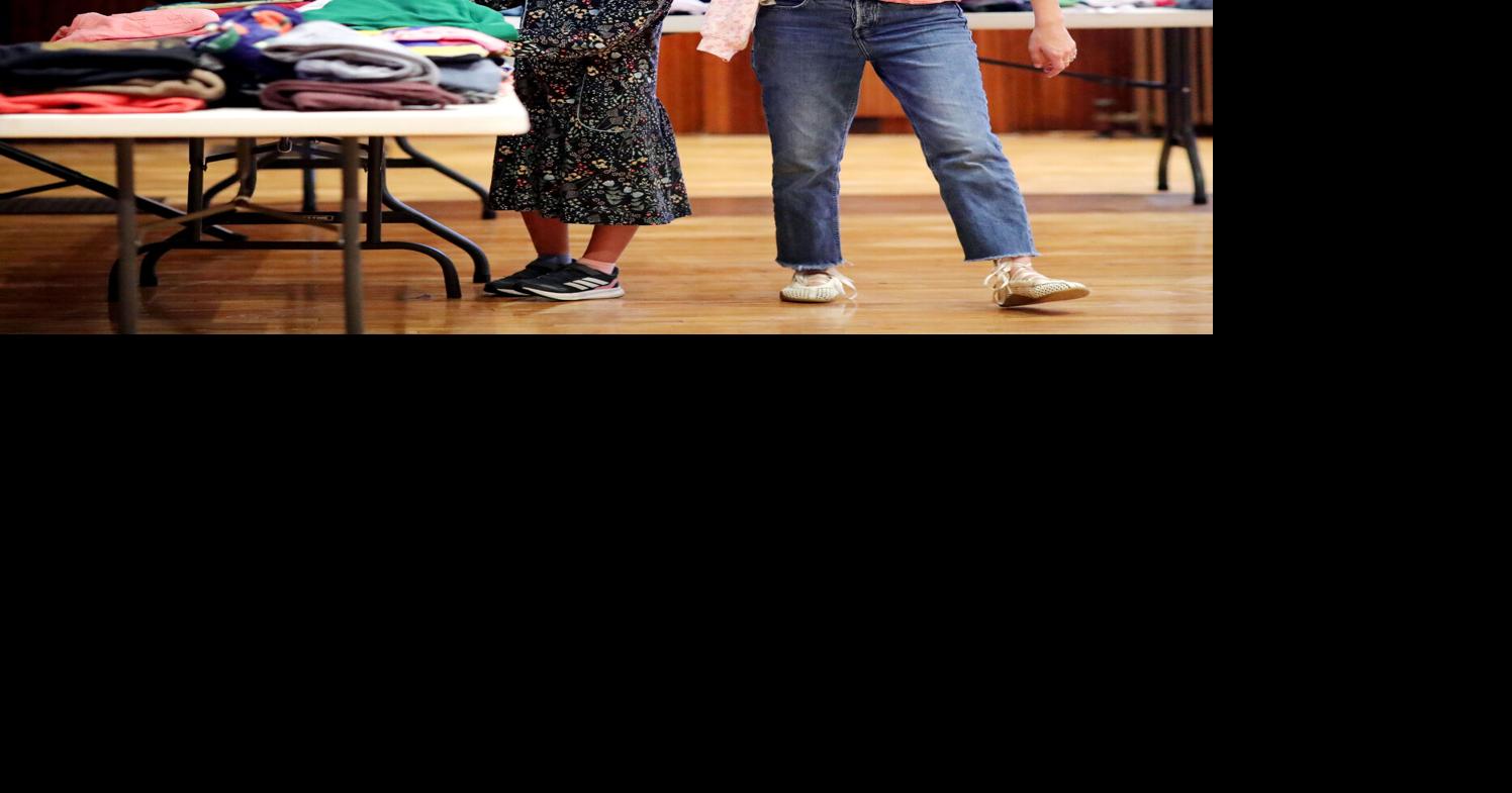 woman and daughter looking at clothes at clothing swap