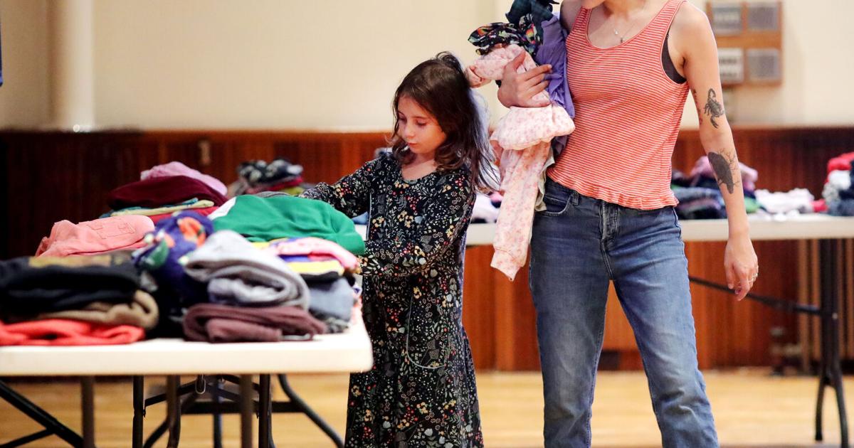 woman and daughter looking at clothes at clothing swap