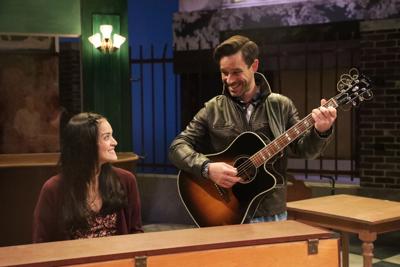Woman listens as man plays guitar