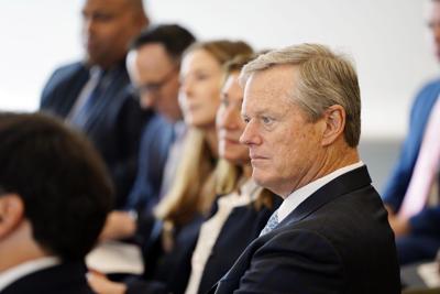 Governor Charlie Baker seated, listening to presentation
