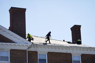 Guys working on roof under blue skies