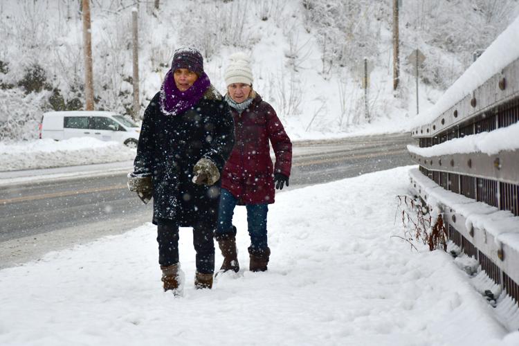 Two women walk in the snow