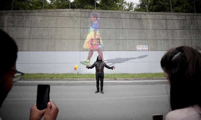 pops peterson raises hands in front of ruby bridges mural