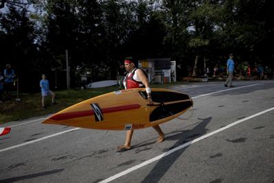 paddler carries board into water