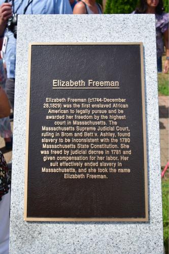 A plaque next to the statue
